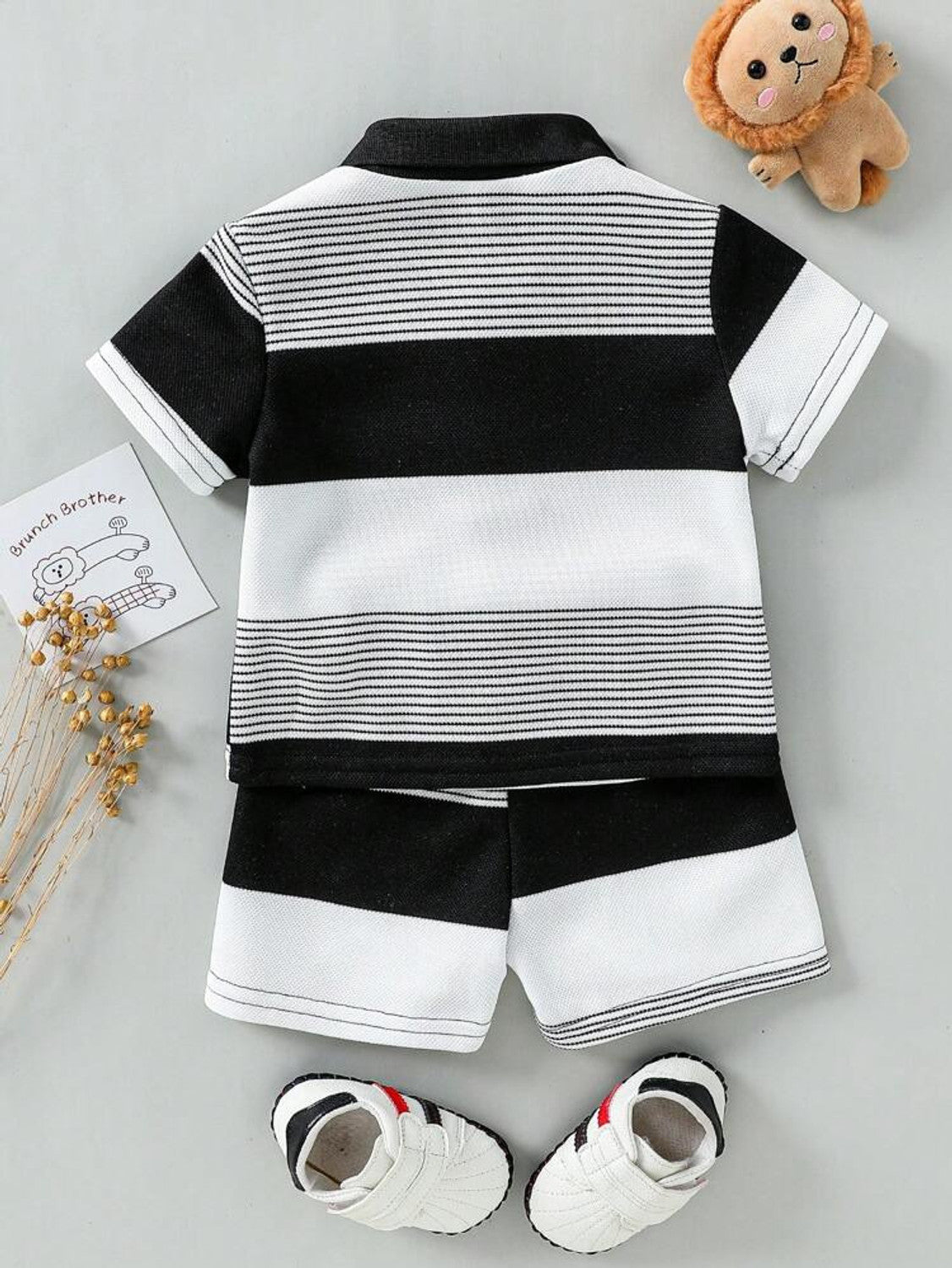 Vista traseira do conjunto infantil polo listrado preto e branco