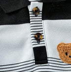 Detalhe da gola polo, botões e aplique de ursinho do conjunto infantil