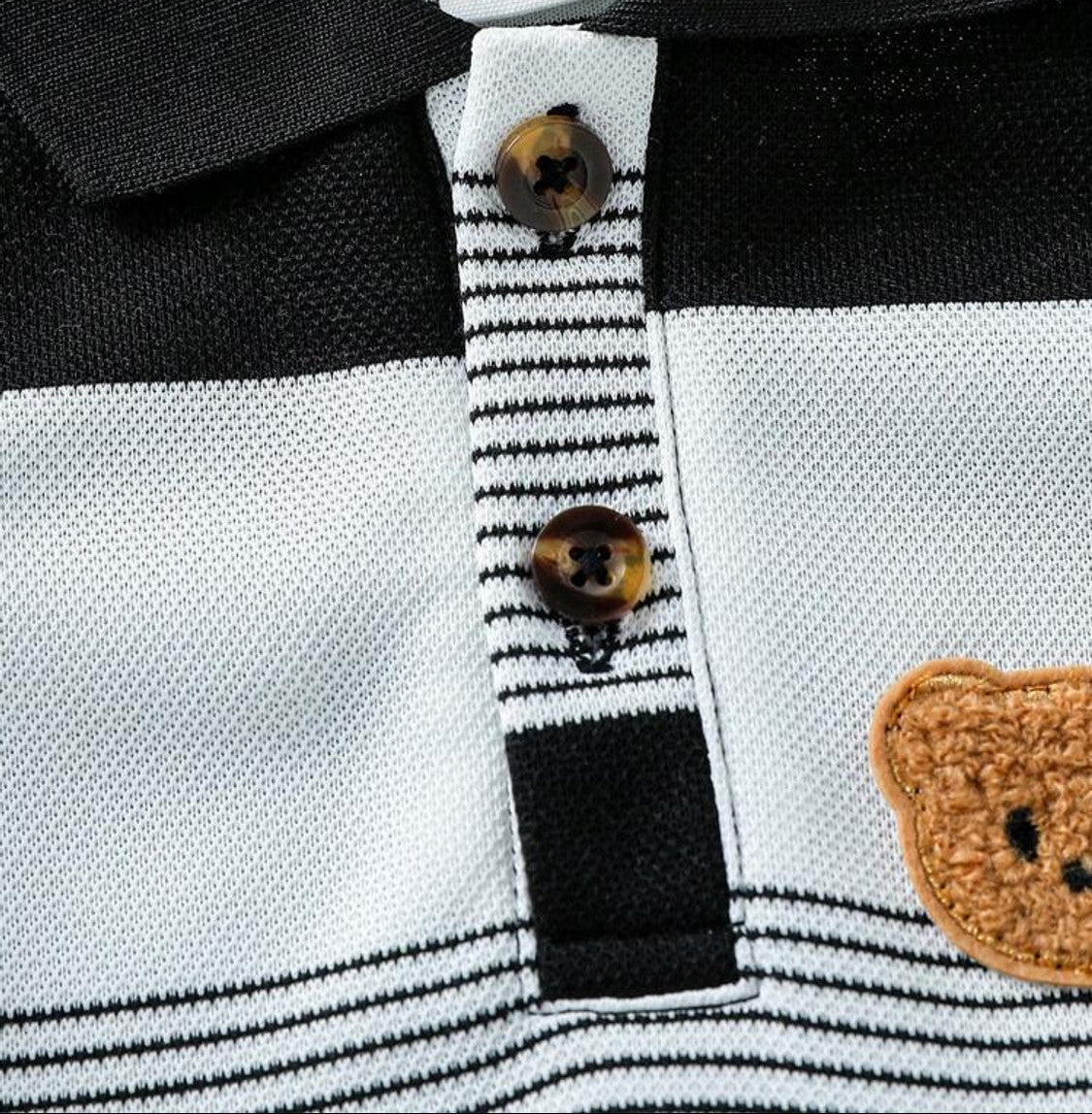 Detalhe da gola polo, botões e aplique de ursinho do conjunto infantil